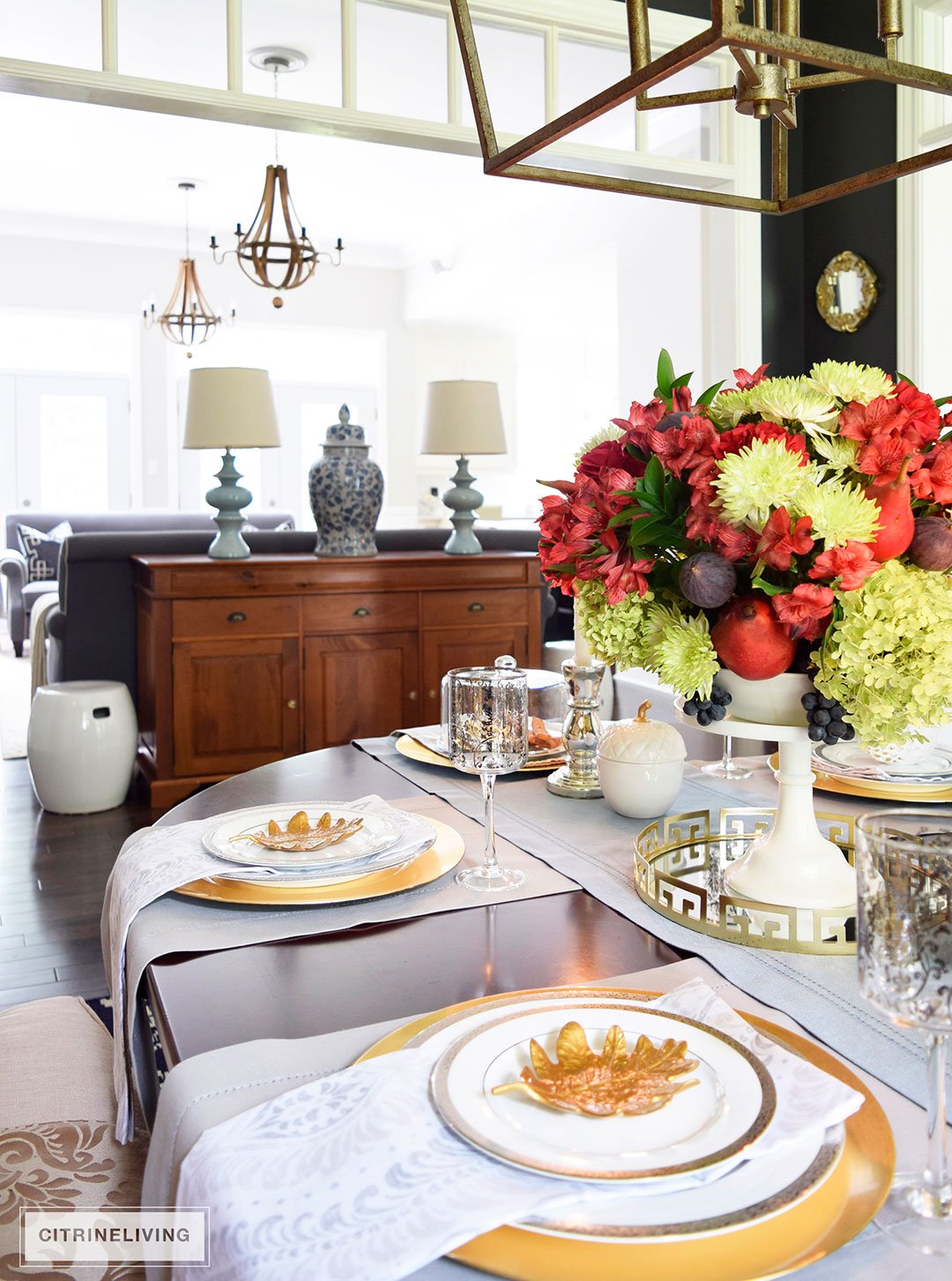 Fall tablescape with metallic touches featuring vibrant red, deep plum and verdant green centrepiece