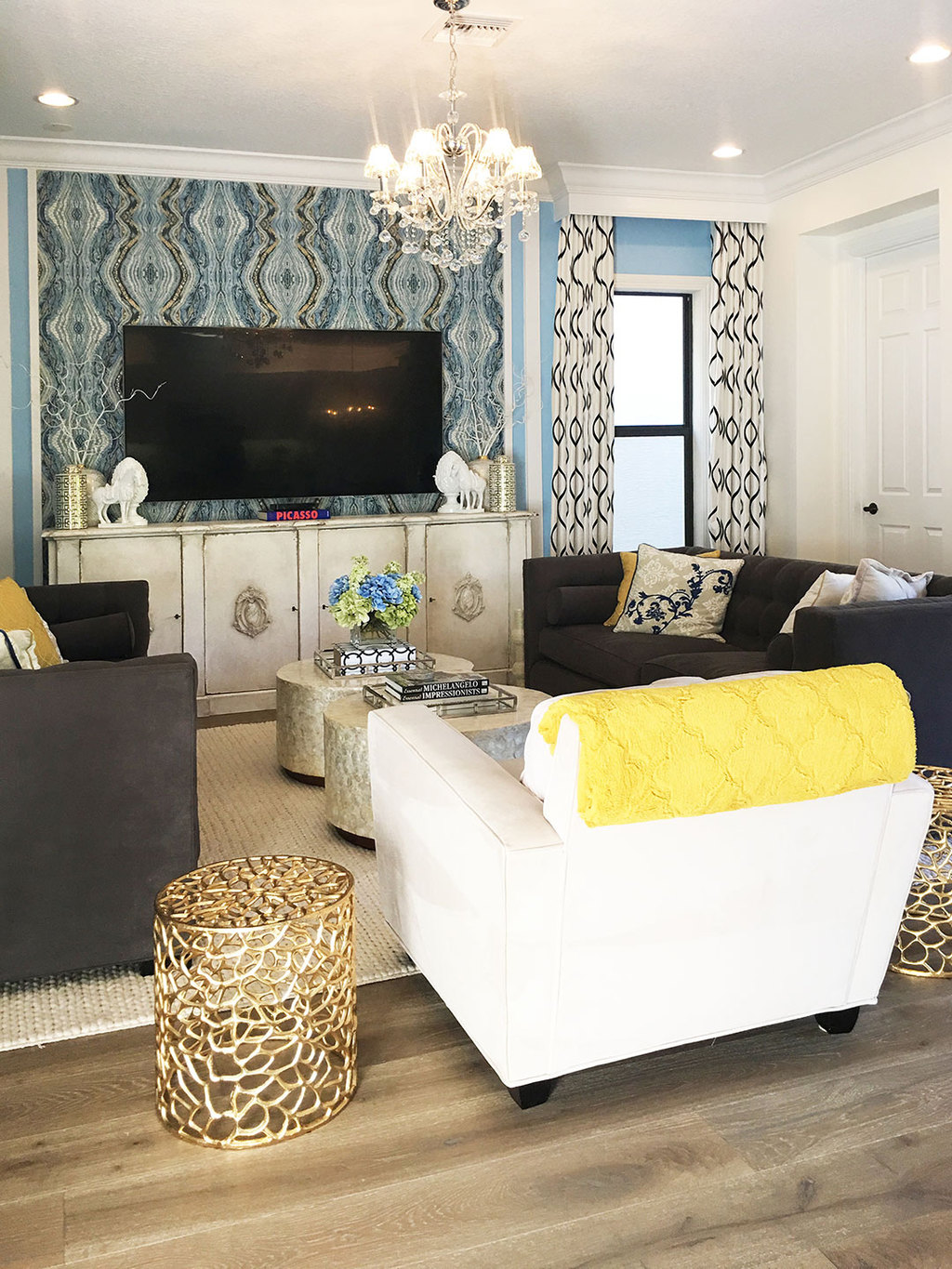 family-room-blue-walls-gold-accents-chandelier