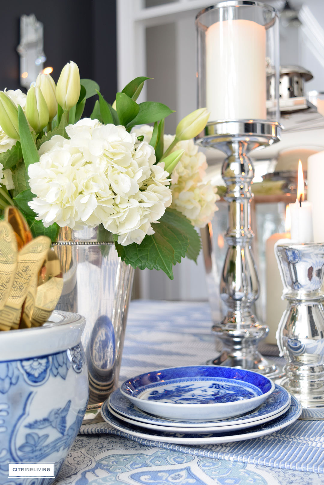 Fresh flowers and layers of blue and white pattern with silver candleholders and gold flatware is perfect for a Spring table.