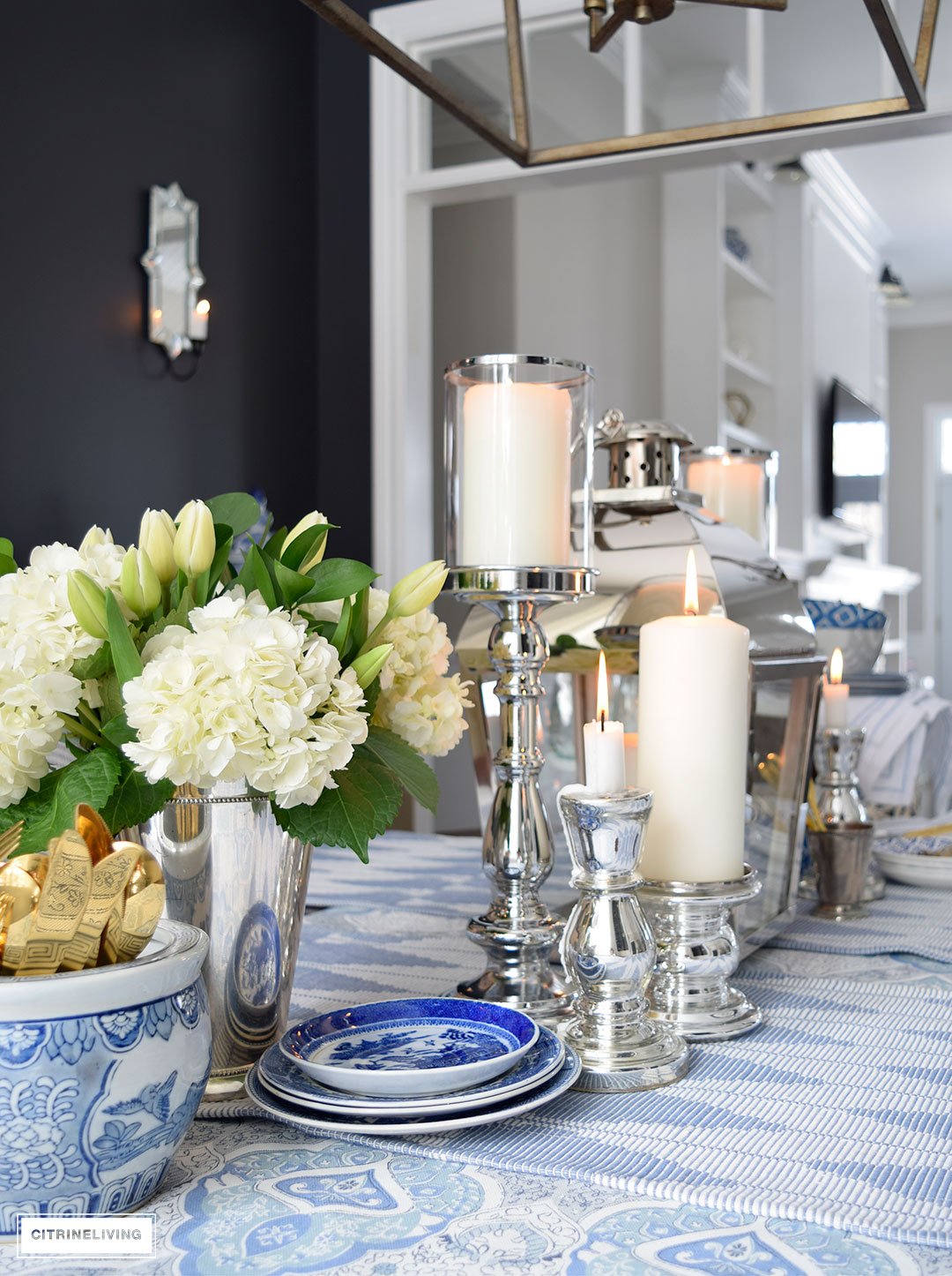 Layers of blue and white pattern with silver candleholders and gold flatware is perfect for a Spring table.