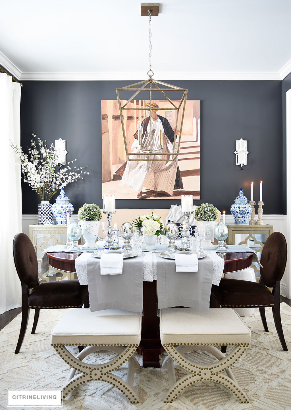 Easter Tablescape set in dining room with elegant black wall color, Cracked Pepper Behr Paint, upholstered stools and settee create an unexpected seating arrangement. 