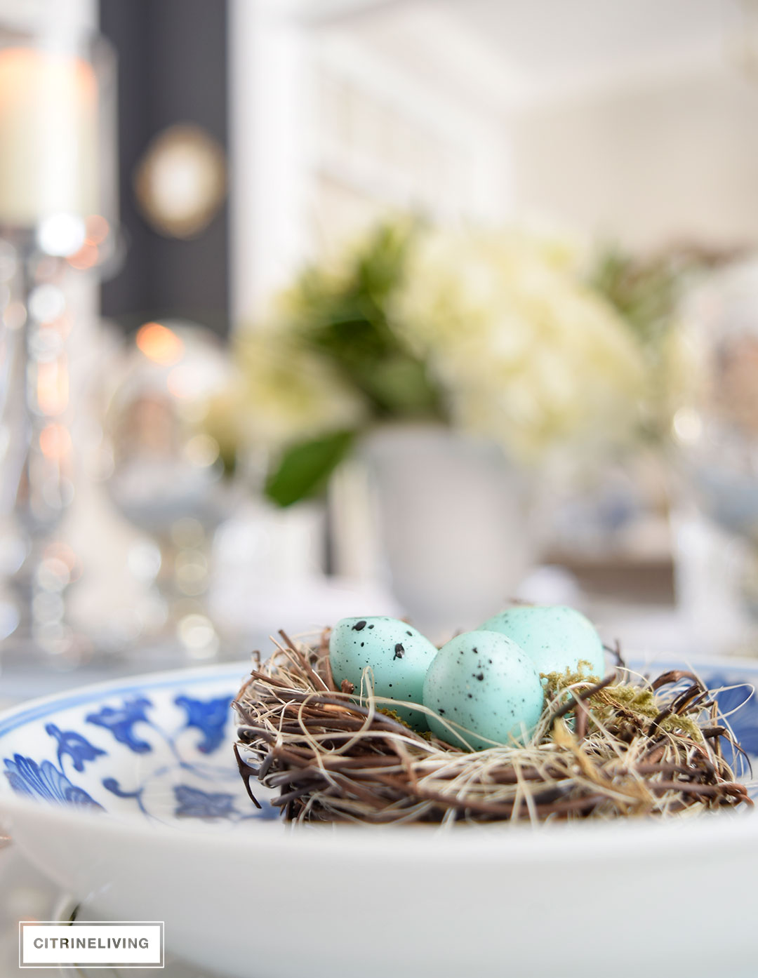 Easter or Spring table setting with pale turquoise eggs atop a mix of blue and white and silver china.