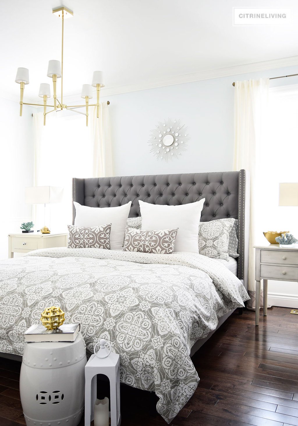 A brass chandelier and accents add modern sophistication to this elegant bedroom.