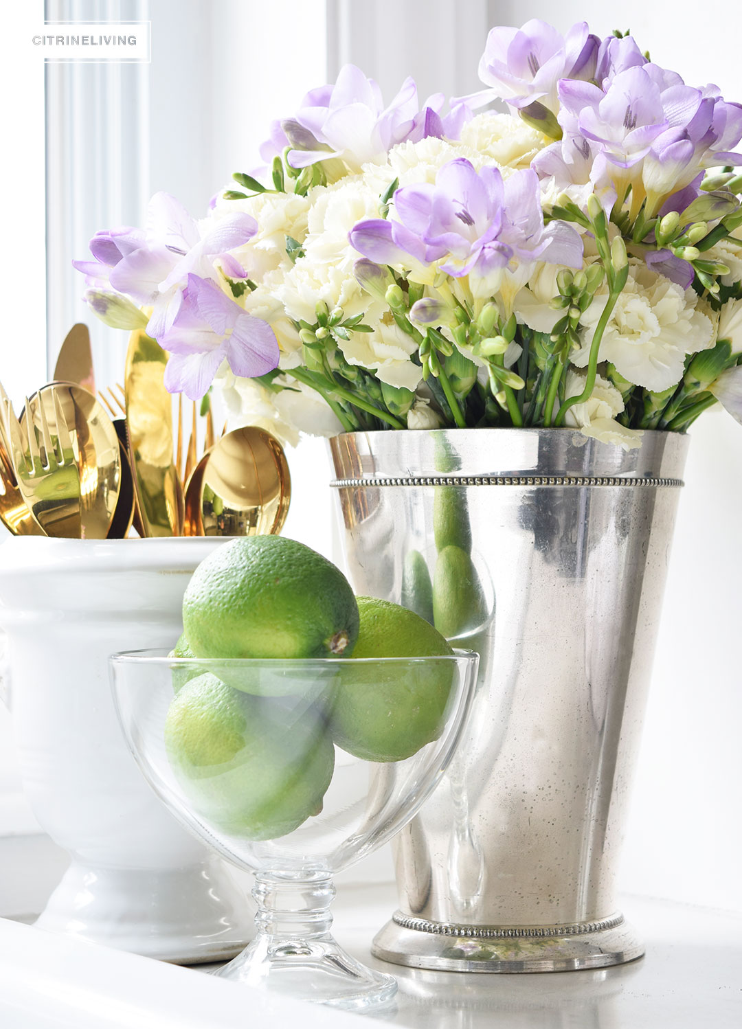 Beautiful Spring flowers - hydrangeas and freesias - paired with fresh limes, creates a vibrant vignette on the in your kitchen.