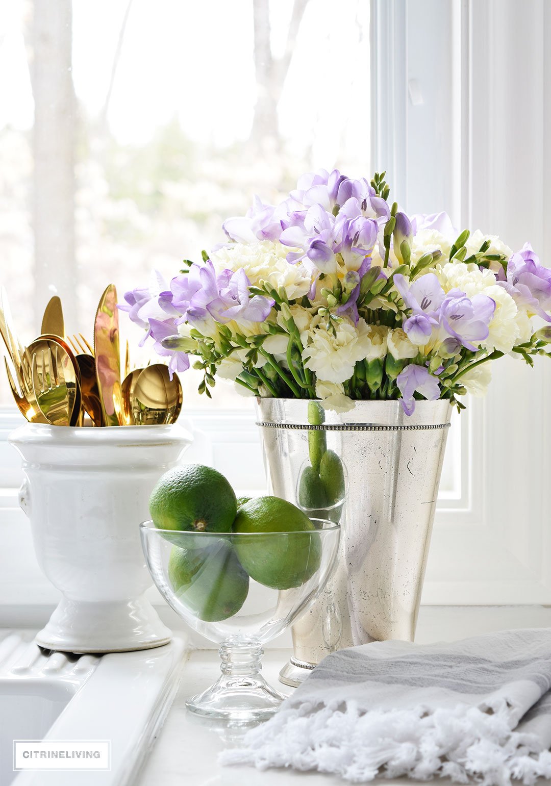 Beautiful Spring flowers - hydrangeas and freesias - paired with fresh limes, creates a vibrant vignette on the in your kitchen.