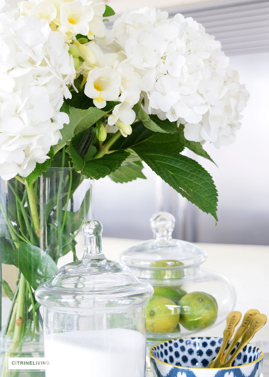 Beautiful hydrangeas and freesias paired with blue and white ikat bowls and dishes create a beautiful kitchen table centerpiece.