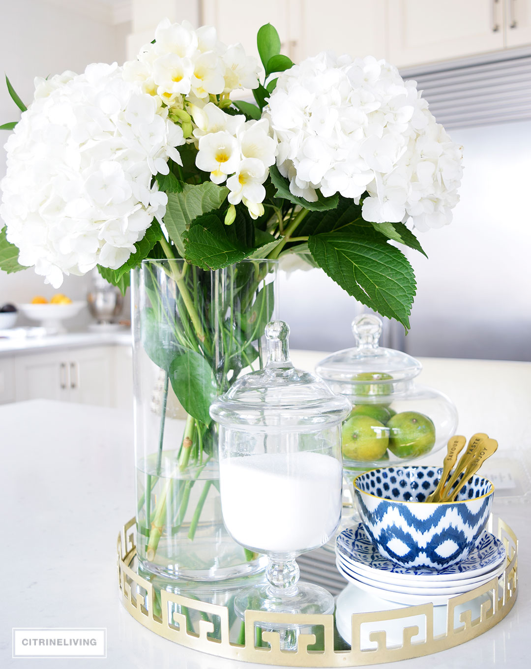 Beautiful hydrangeas and freesias paired with blue and white ikat bowls and dishes create a beautiful kitchen table centerpiece.