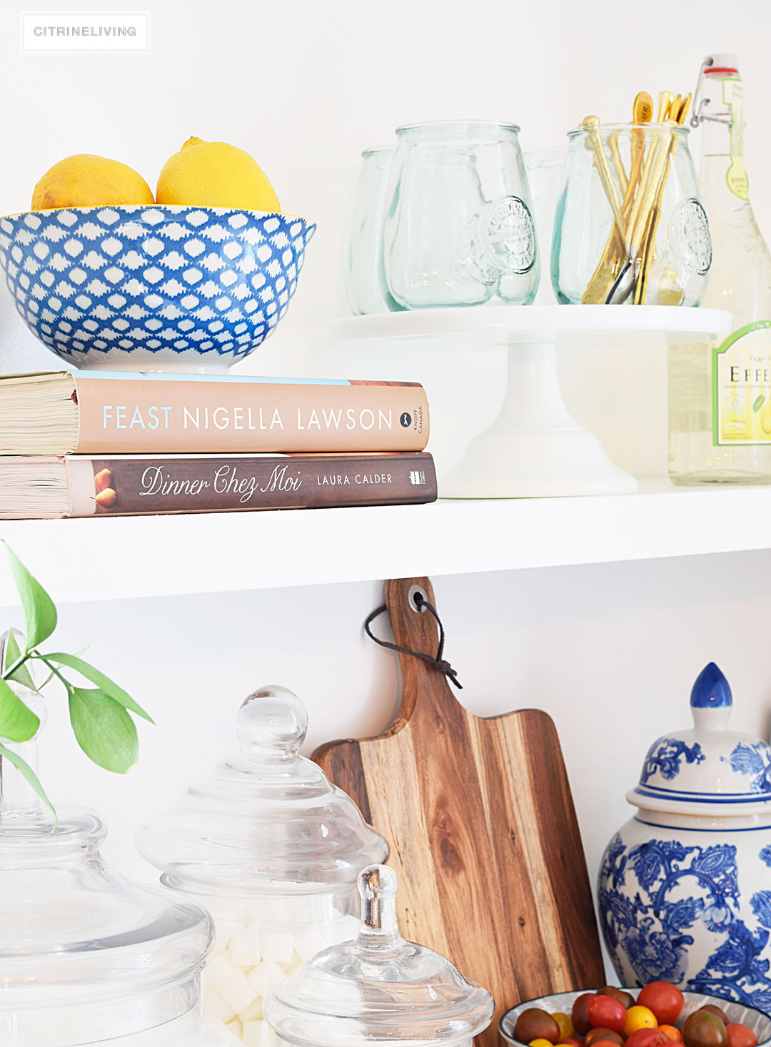 Create a curated, collected, artisanal look on your kitchen shelves with a mix of cookbooks, wood, glass, blue and white, and gourmet inspired accents.
