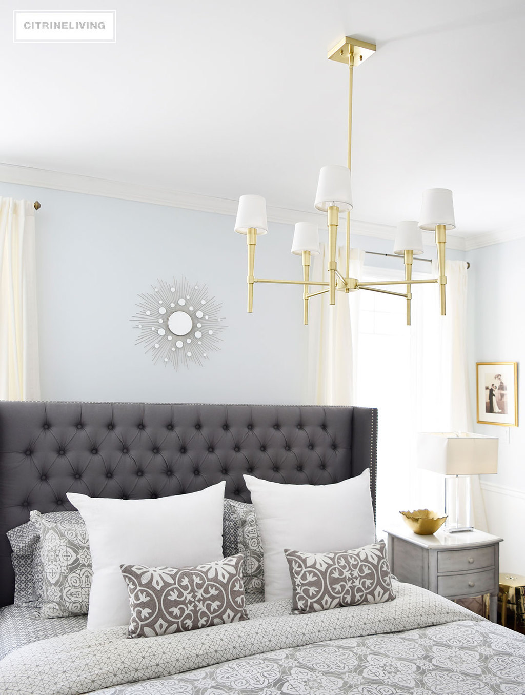 A brass chandelier and accents add modern sophistication to this elegant bedroom.