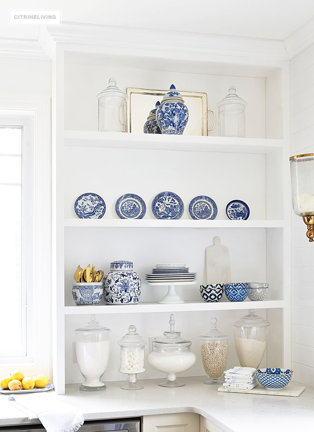 A gorgeous display of blue and white accessories and dishware on open shelving is sophisticated and elegant. 