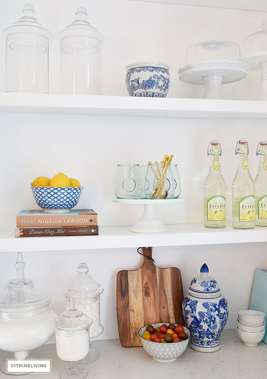 Create a curated, collected, artisanal look on your kitchen shelves with a mix of cookbooks, wood, glass, blue and white, and gourmet inspired accents.