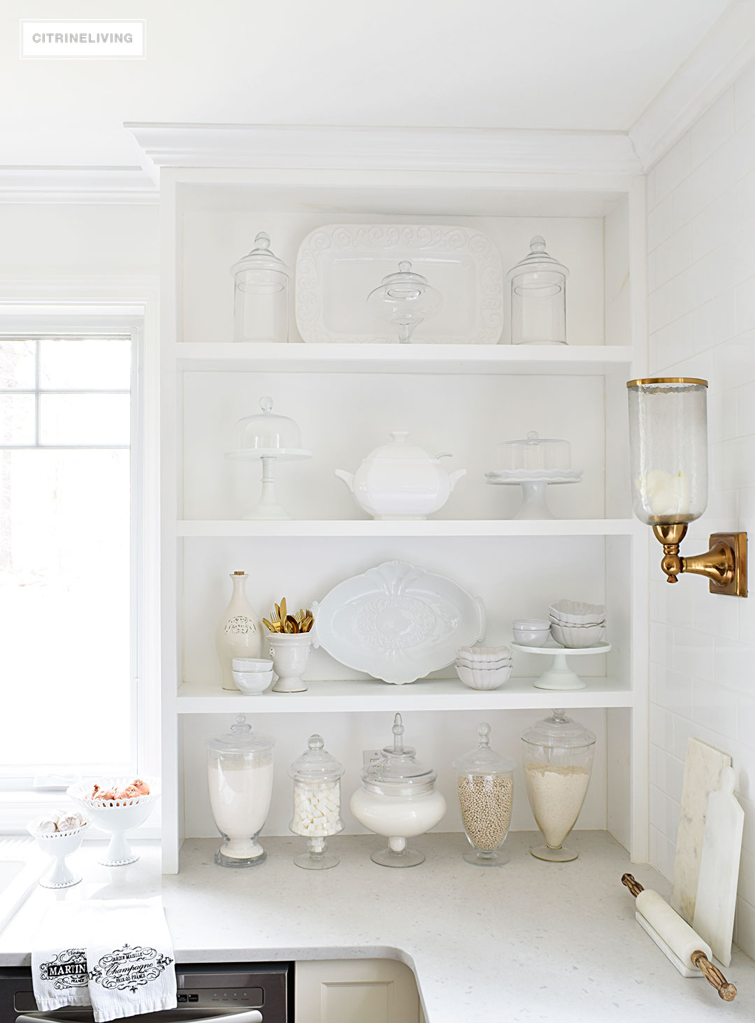 Bring vintage flair to your open kitchen shelving with a mix of white and cream serving pieces and dishware for a fresh, layered look.