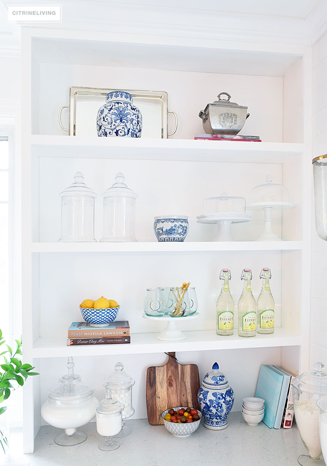 Create a curated, collected, artisanal look on your kitchen shelves with a mix of cookbooks, wood, glass, blue and white, and gourmet inspired accents.