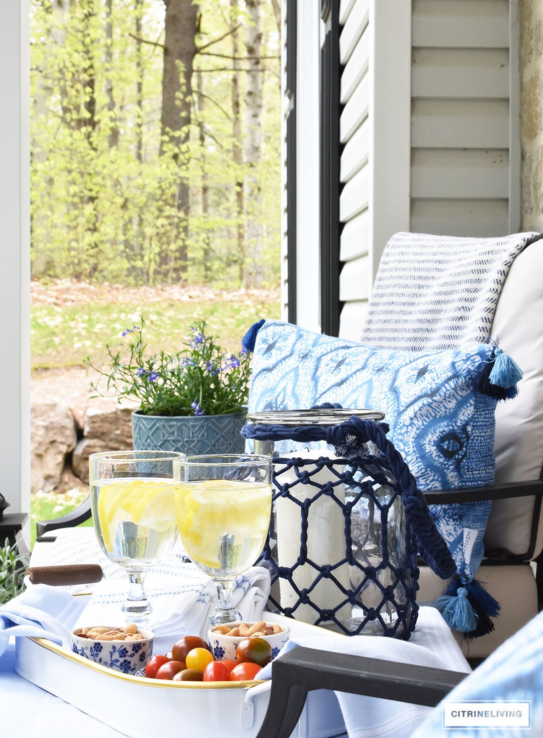 Create a chic Spring porch decorated with blue and white accents: garden stools, potted plants with some boho-chic and nautical pieces thrown into the mix!