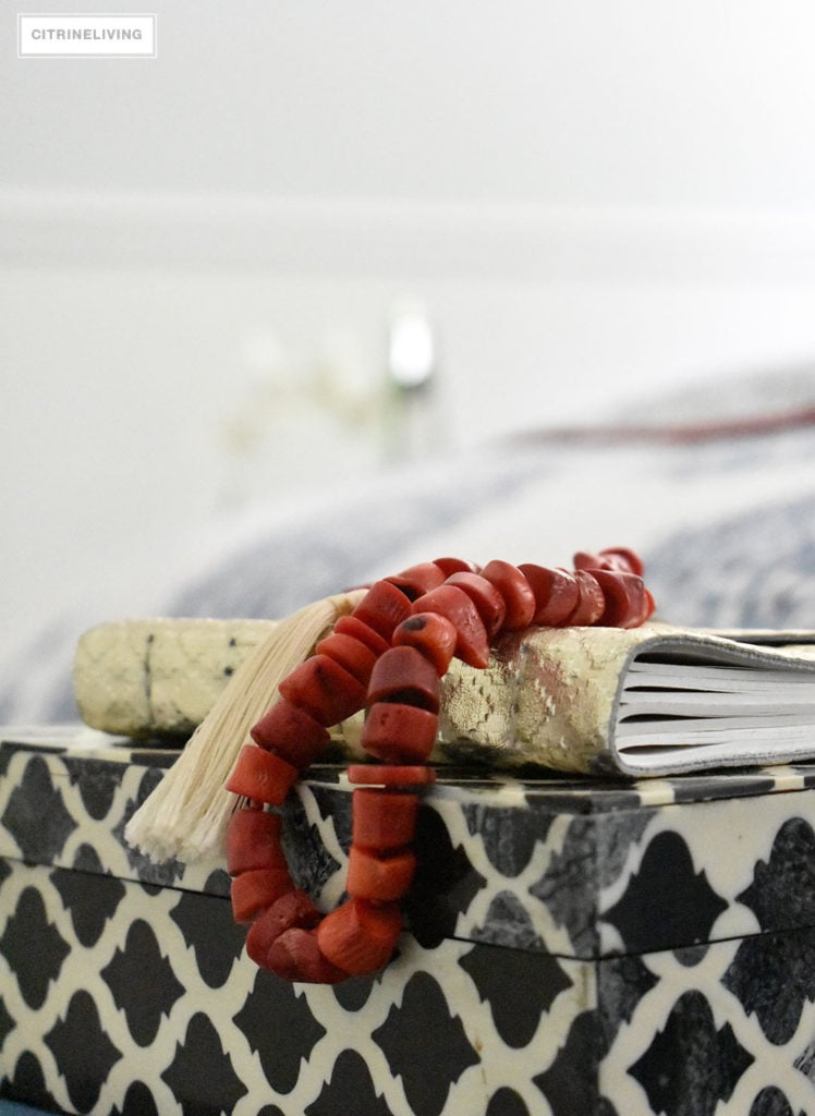 A mix of bold, graphic accessories in a blue and white coastal inspired bedroom brings a modern, eclectic touch.