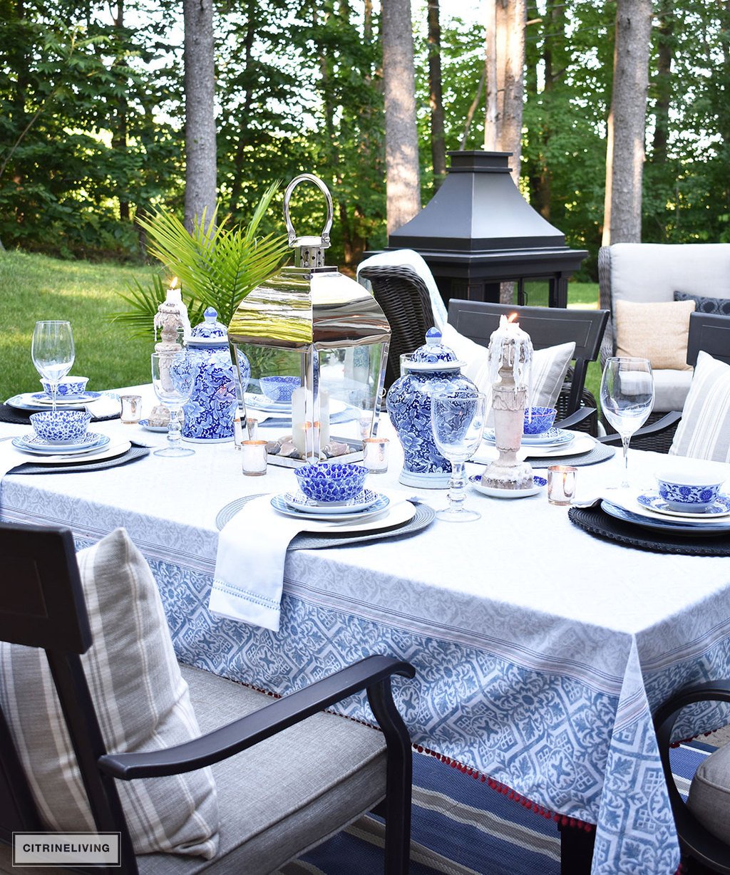 An outdoor tablescape with blue and white ginger jars and a mix of blue and white patterned dishes brings a casual yet elegant look to your outdoor space.