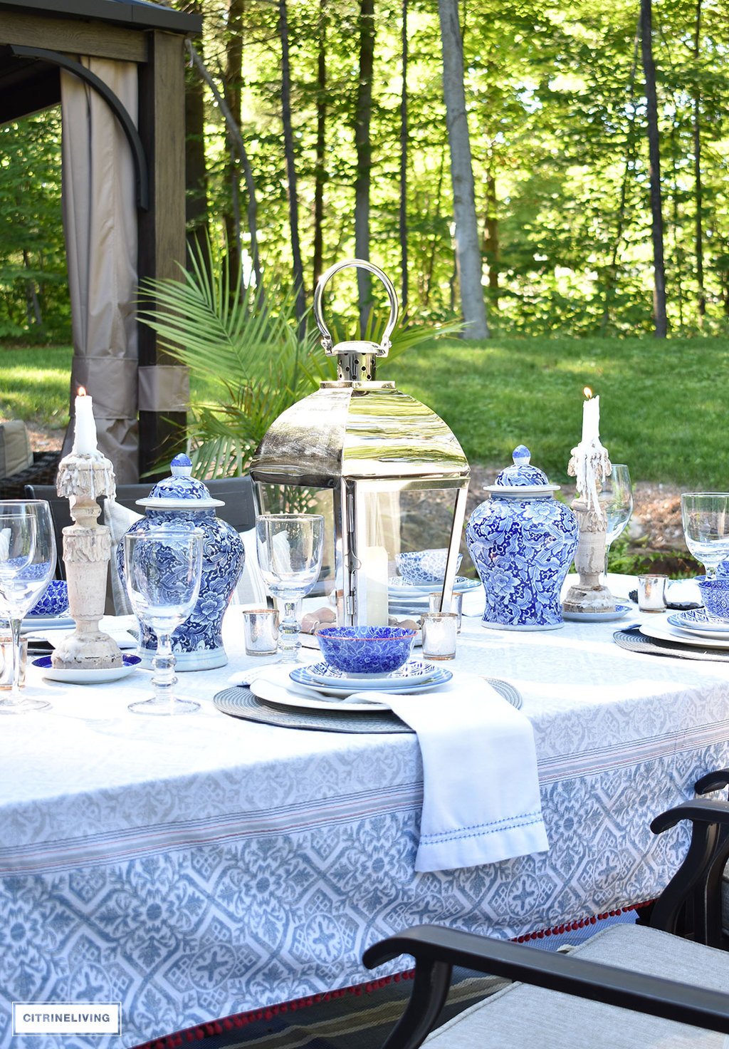 An outdoor tablescape with blue and white ginger jars and a mix of blue and white patterned dishes brings a casual yet elegant look to your outdoor space.