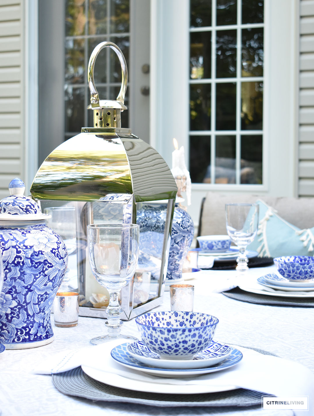 An outdoor tablescape with blue and white ginger jars and a mix of blue and white patterned dishes brings a casual yet elegant look to your outdoor space.