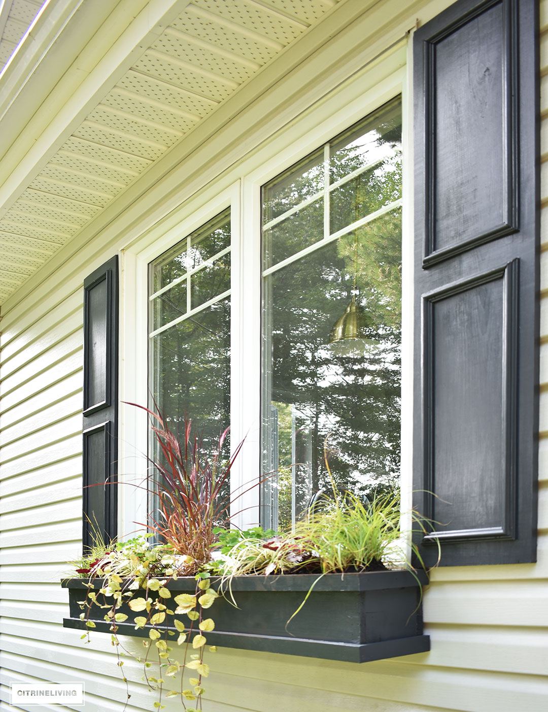 DIY black shutters and window boxes add character to this window.