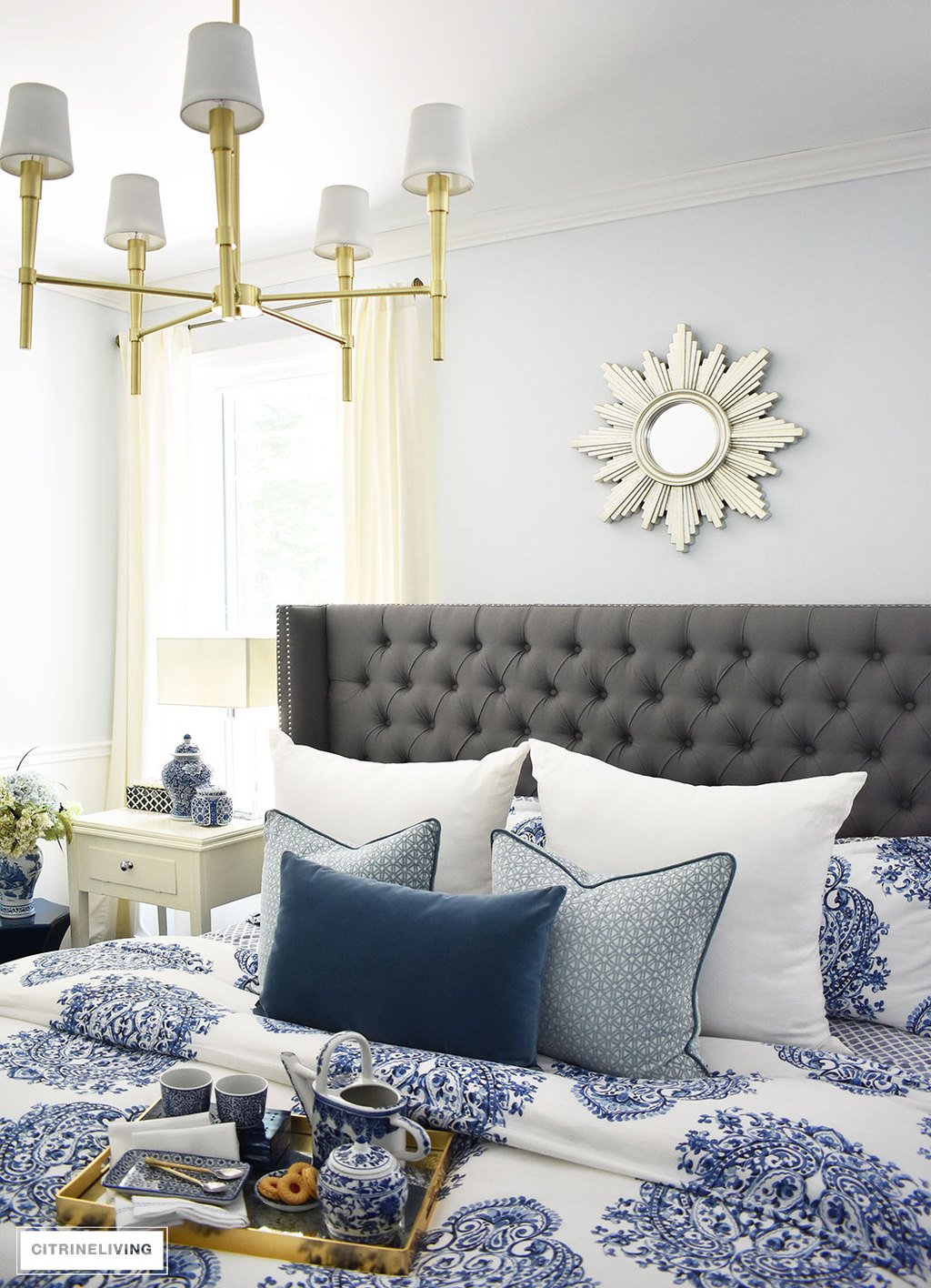 A sunburst mirror is a chic and classic addition to any space! This beautiful blue and white bedroom accented with a mix of cool and warm metals is elegant, warm and inviting. A metallic sunburst mirror as the perfect finishing touch.