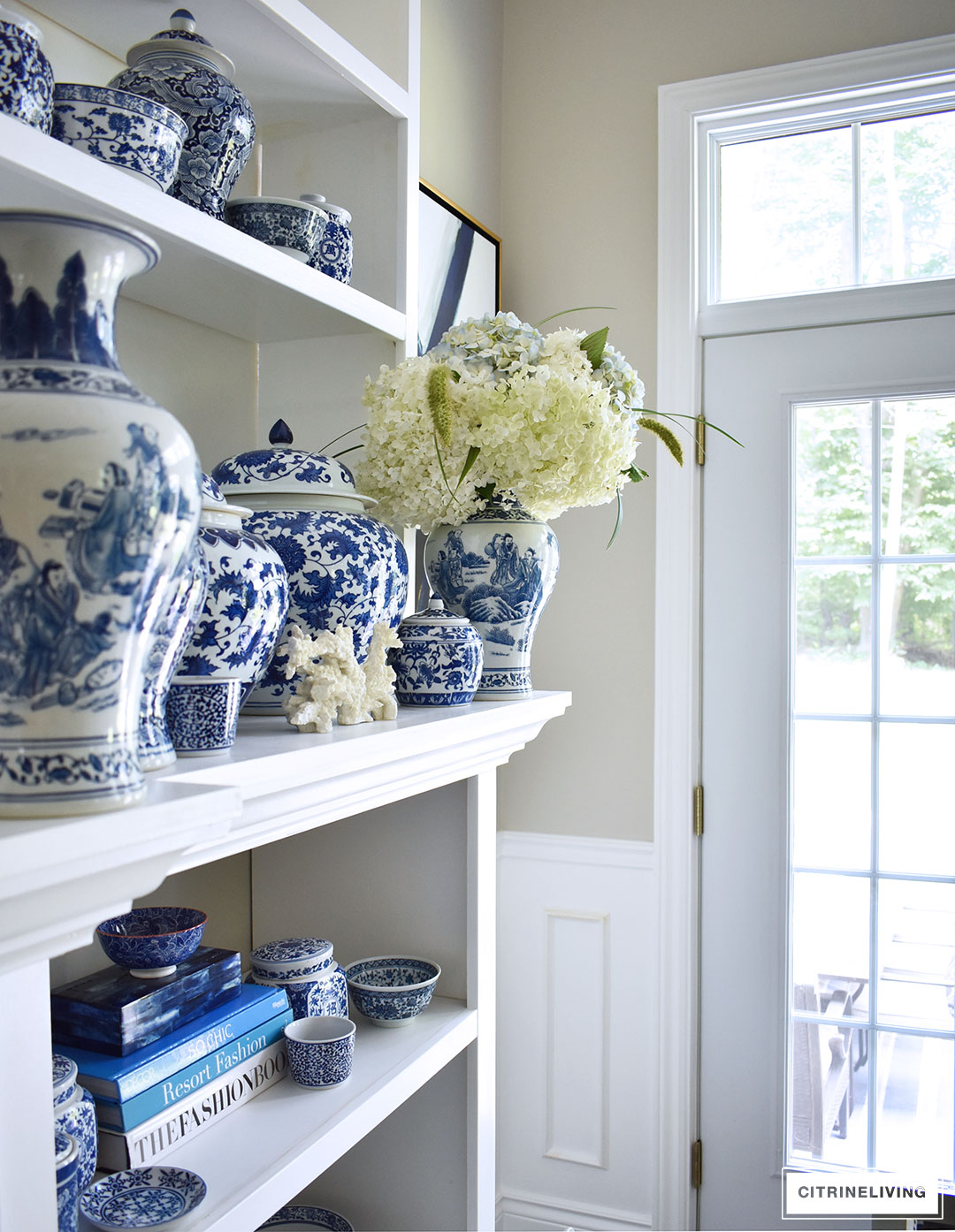 blue and white ginger jar vase bowl collection on white shelves with hydrageas