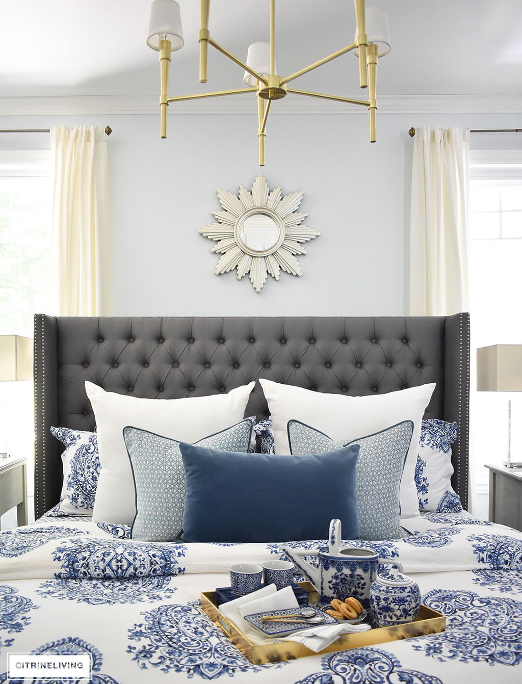 A sunburst mirror is a chic and classic addition to any space! This beautiful blue and white bedroom accented with a mix of cool and warm metals is elegant, warm and inviting. A metallic sunburst mirror as the perfect finishing touch.