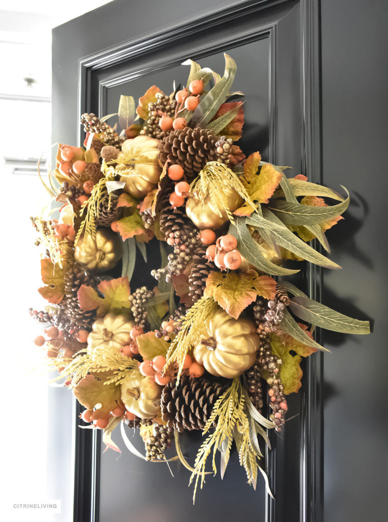 Fall decorating. An elegant entry way featuring a traditional black front door with a rich and sophisticated Fall wreath. 
