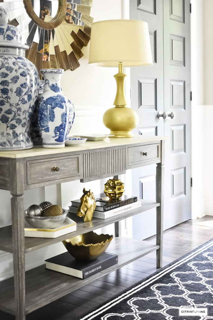 Fall home tour with elegant entryway featuring console table with layers of gold accessories and blue and white ginger jars.