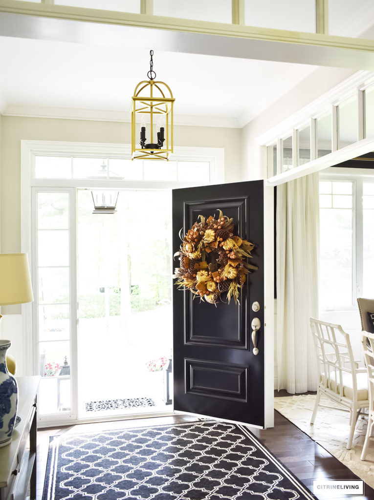 Fall decorating. An elegant entry way featuring a traditional black front door with a rich and sophisticated Fall wreath. 