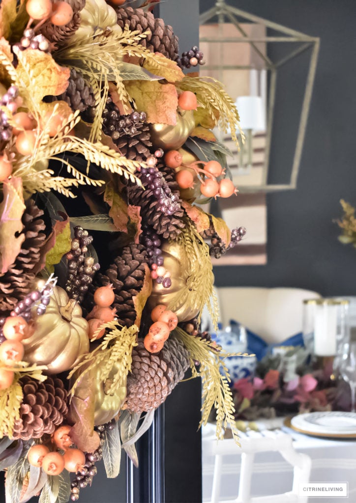 Beautiful Fall wreath with rich burgundy, orange and gold details adorns this traditional black front door.