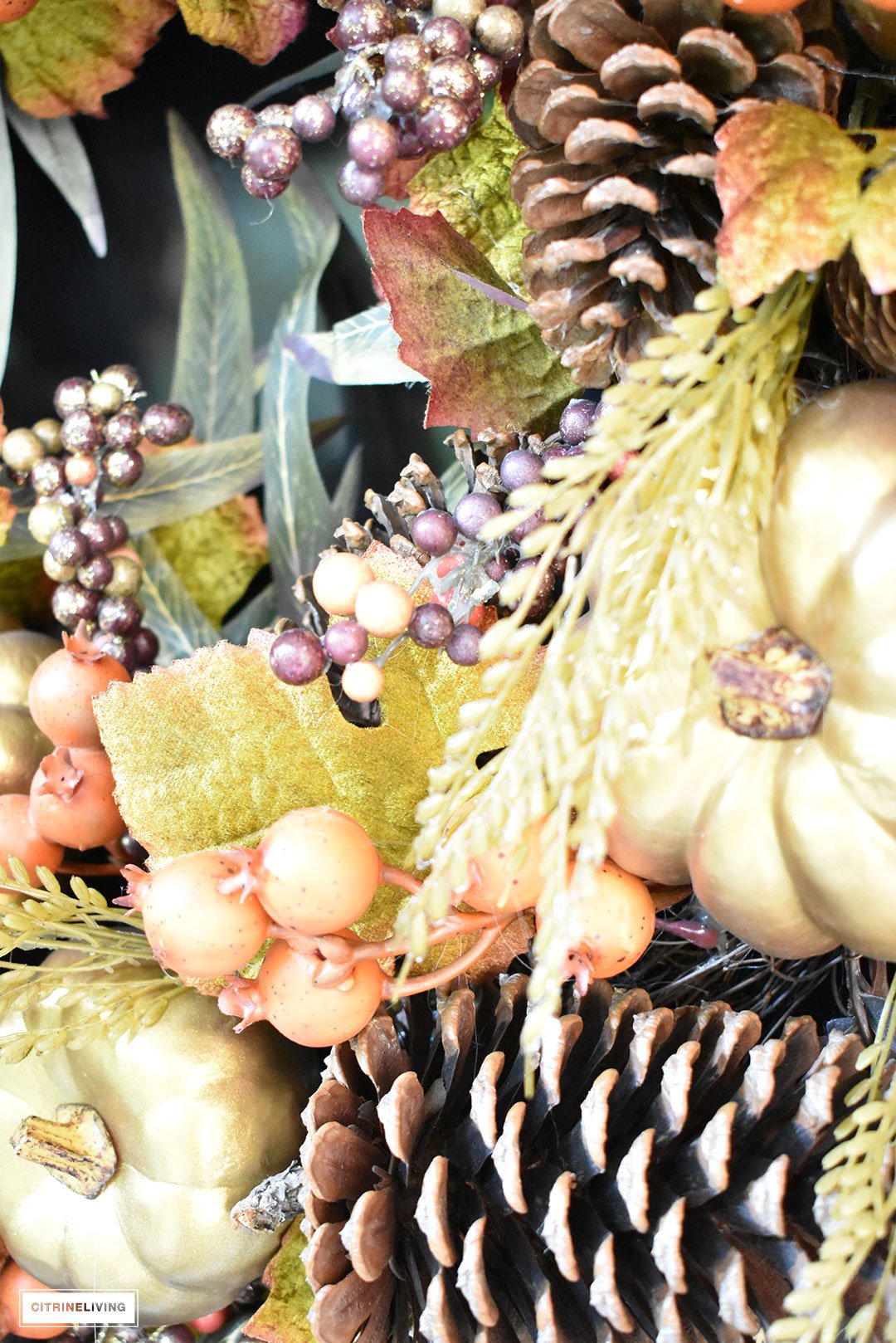 A simple and elegant front porch decorated for Fall with seasonal flowers in autumnal colors, and a sophisticated overscale wreath for the front door.