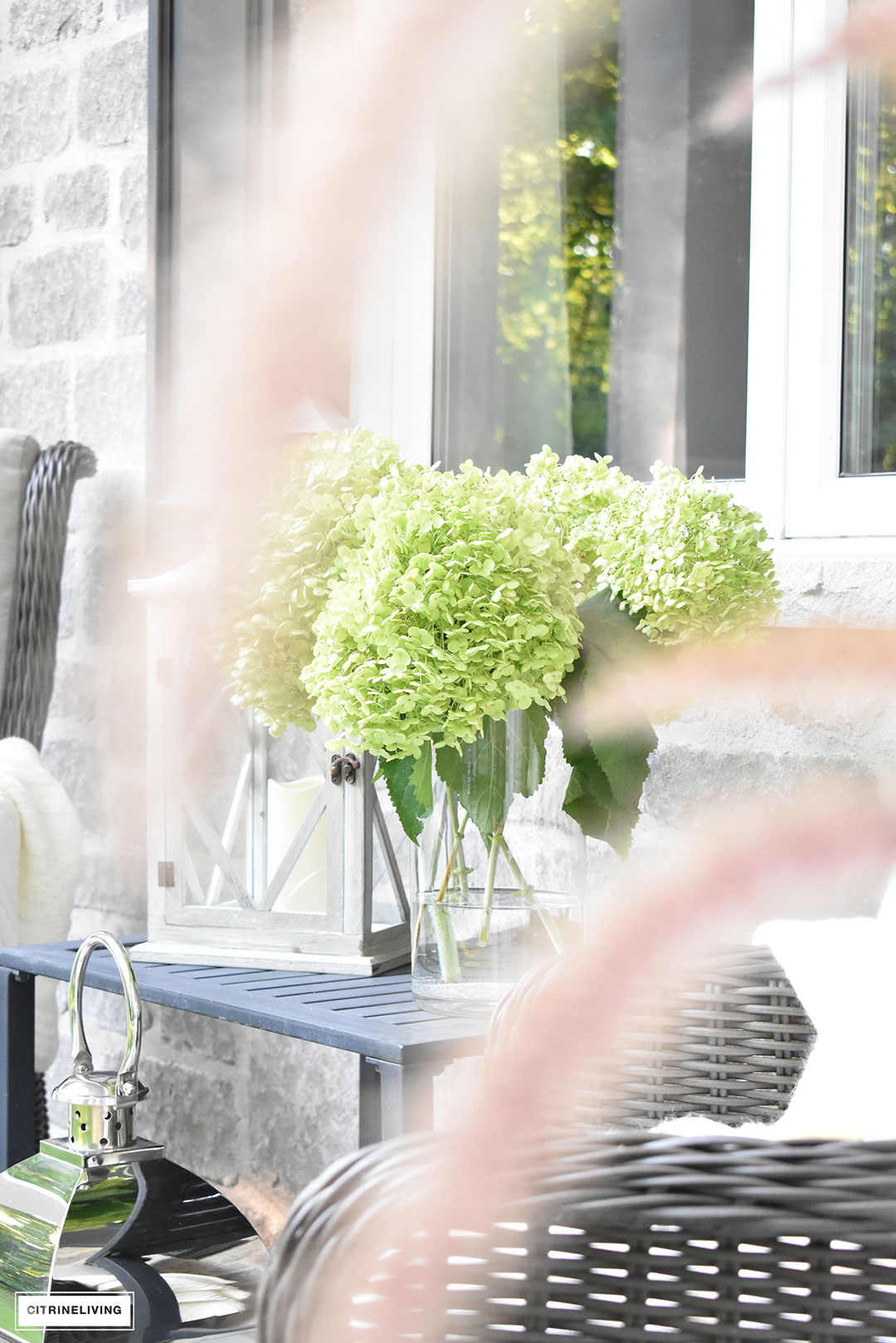 Create a cozy seating nook on your front porch this Fall, layered with blankets, fresh hydrangeas and lanterns.