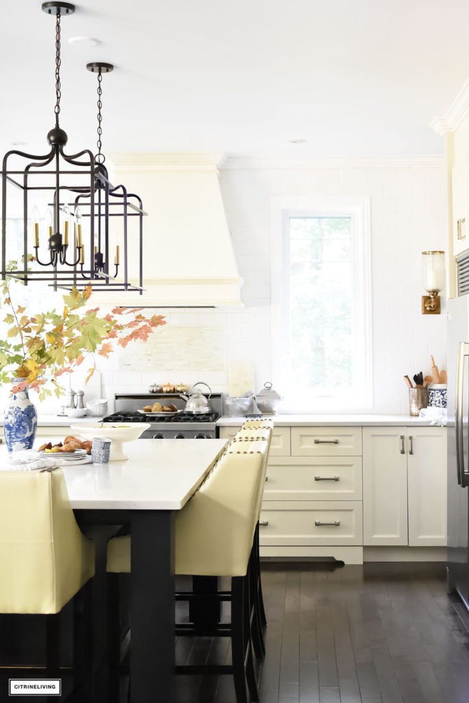 Fall Home Tour - casual elegant black and white kitchen with large black island and lantern style pendant lighting. Brass wall sconces.