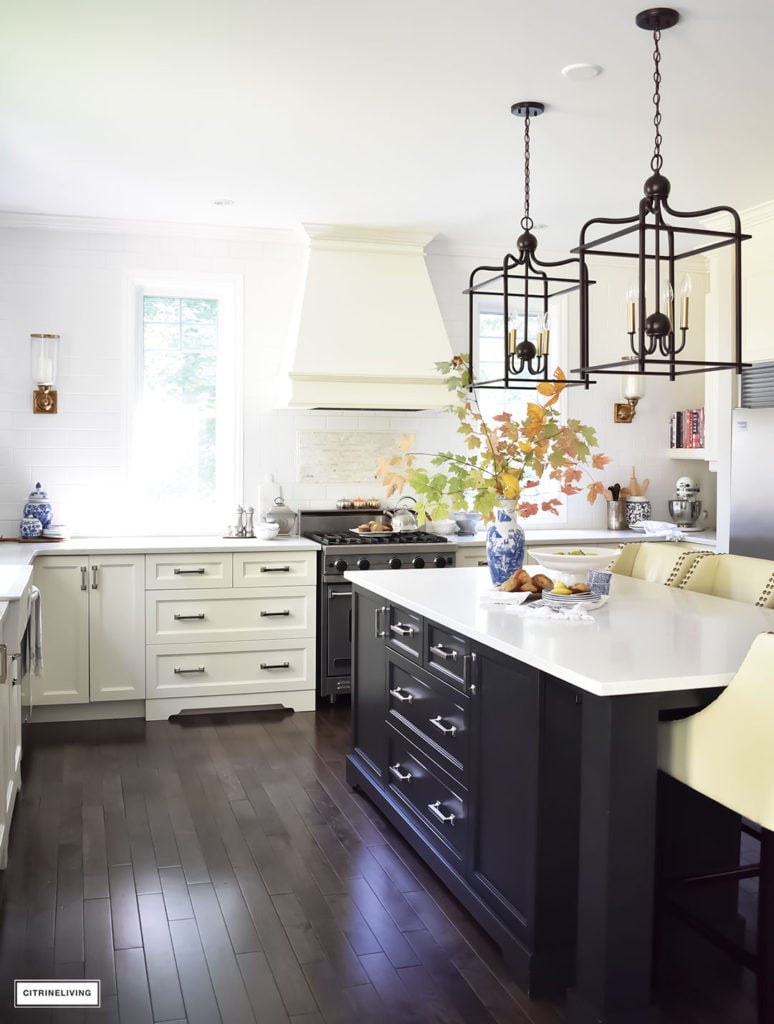 Fall Home Tour - casual elegant black and white kitchen with large black island and lantern style pendant lighting. Blue and white vases and Fall foliage.