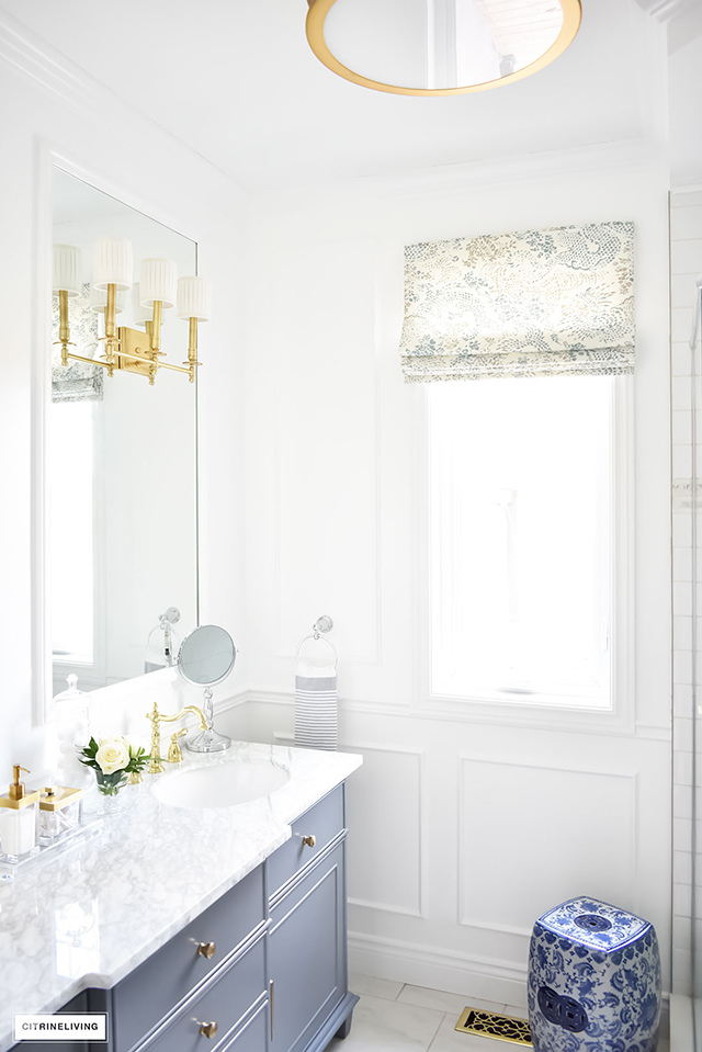 Gorgeous traditional meets modern master bathroom reveal with an elegant color palette of grey, white and brass, accented with blue and white chinoiserie.