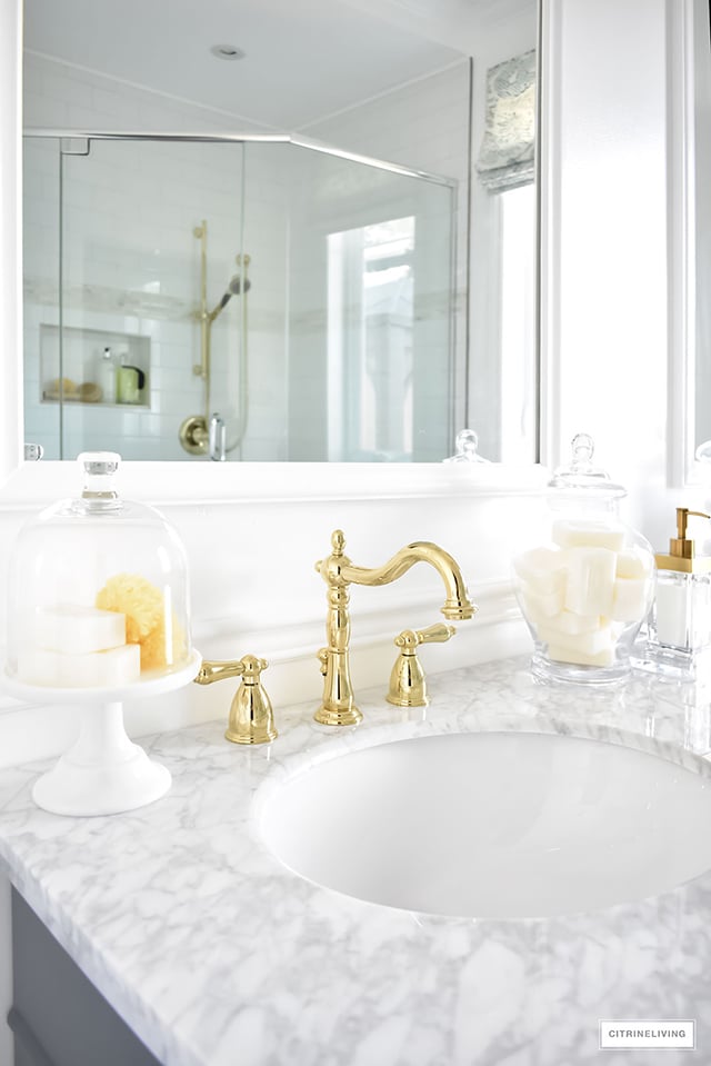 Gorgeous traditional meets modern master bathroom reveal with an elegant color palette of grey, white and brass, accented with blue and white chinoiserie.