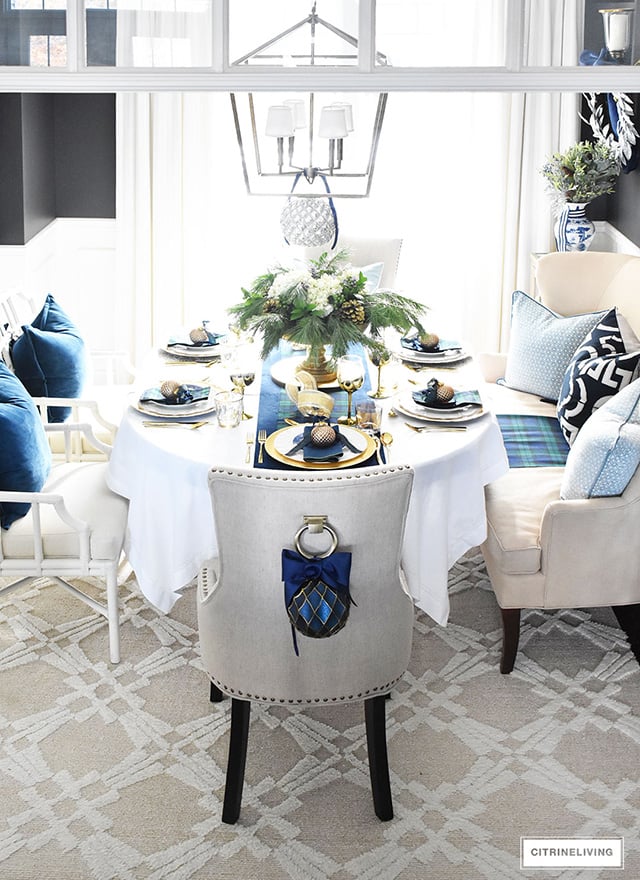 Gorgeous Christmas tablescape with classic navy and green tartan, accented with gold ornaments, chargers, flatware and glassware.