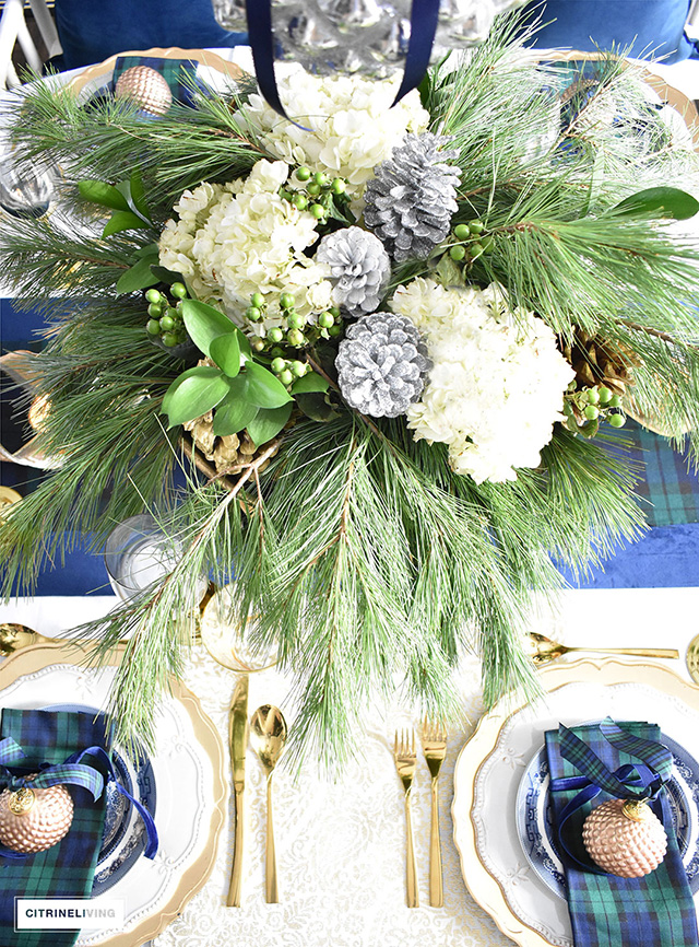 Gorgeous Christmas tablescape with classic navy and green tartan, accented with gold ornaments, chargers, flatware and glassware.