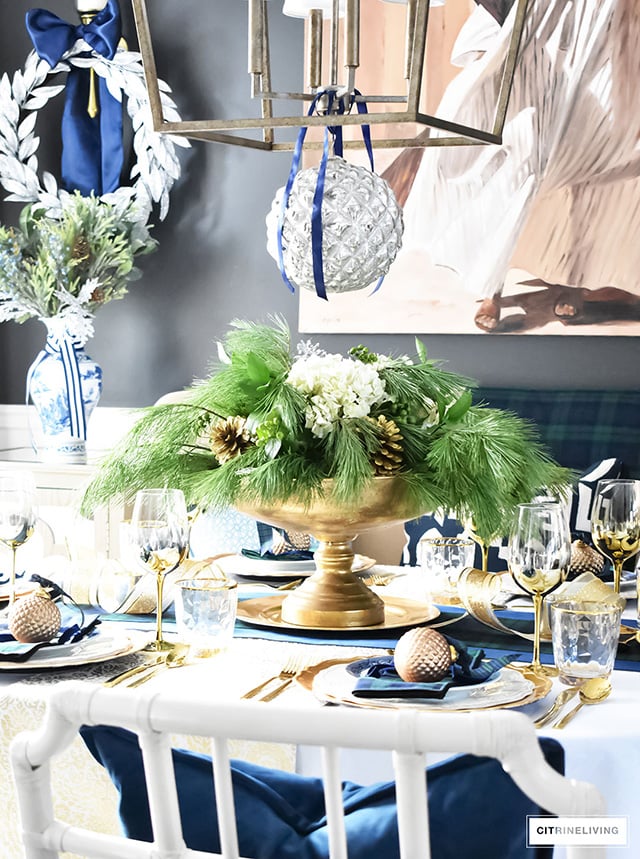 Gorgeous Christmas tablescape with classic navy and green tartan, accented with gold ornaments, chargers, flatware and glassware.