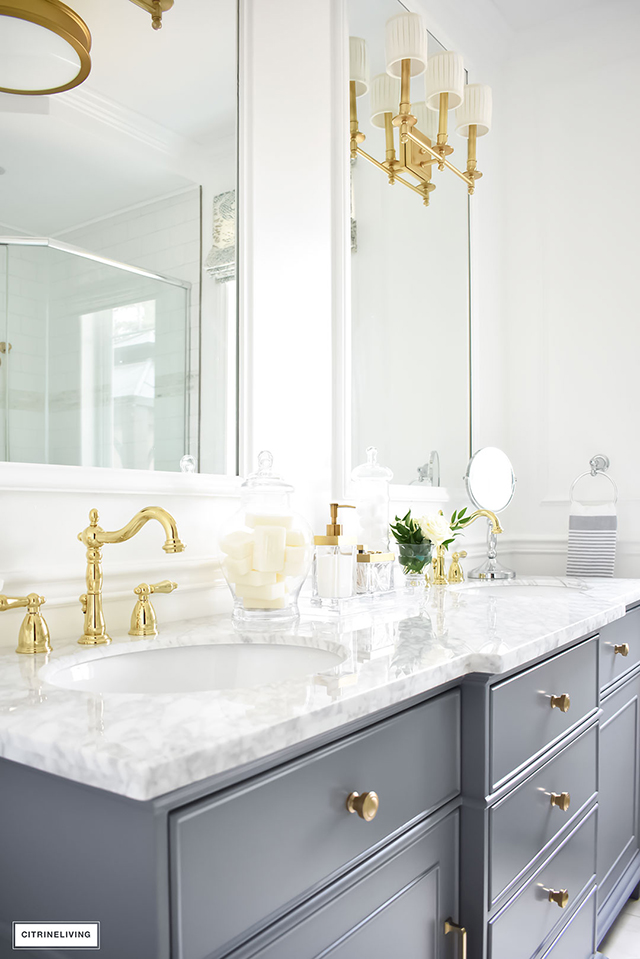 Gorgeous traditional meets modern master bathroom reveal with an elegant color palette of grey, white and brass, accented with blue and white chinoiserie.