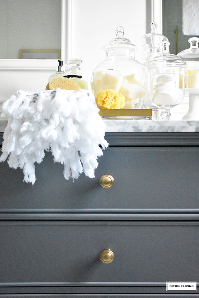Gorgeous master bathroom makeover featuring marble, brass and beautiful accessories.