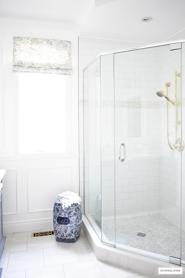 Gorgeous traditional meets modern master bathroom reveal with an elegant color palette of grey, white and brass, accented with blue and white chinoiserie.