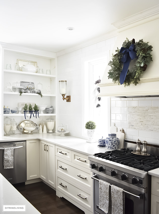 A beautiful Christmas kitchen with blue and white chinoiserie, paired with holiday greenery for a sophisticated, festive and elegant look.