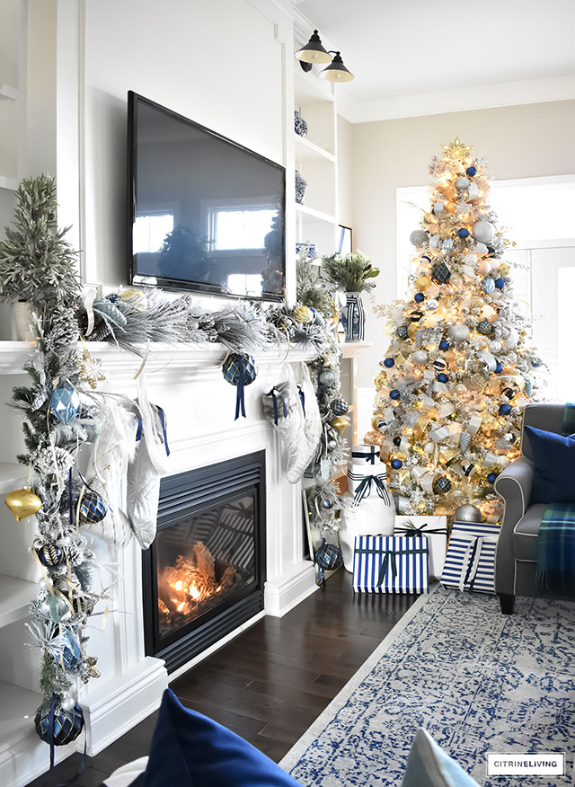 Christmas Home Tour - Gorgeous living room dressed in blues, gold, silver and flocked greenery is sophisticated,elegant and has an elevated look and feel.