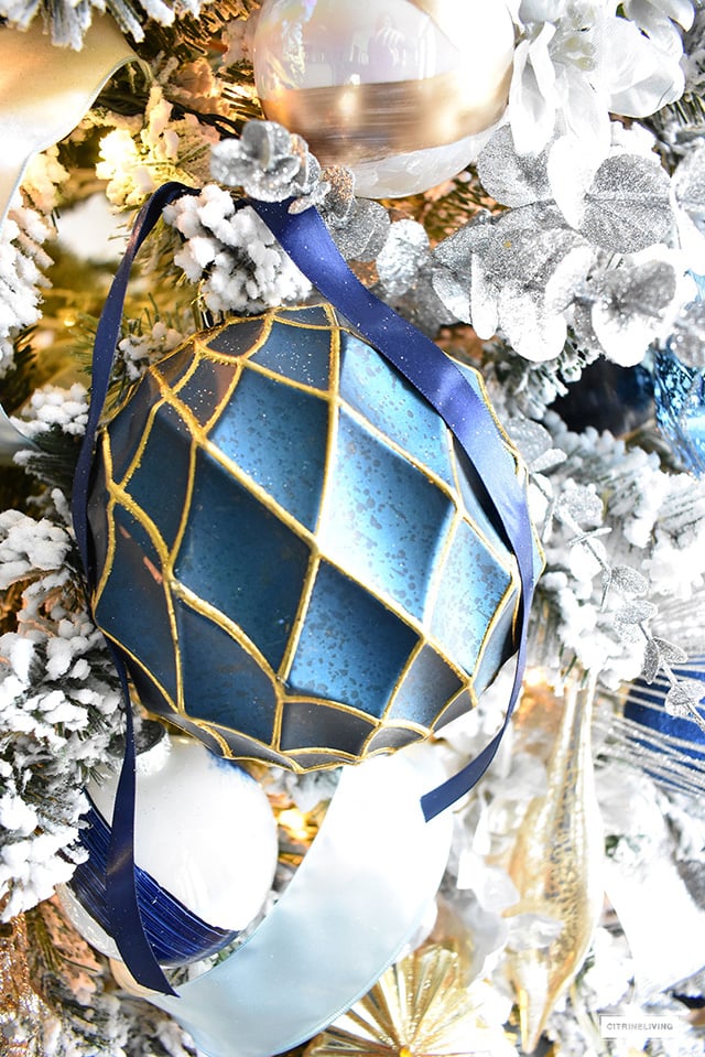 Beautiful, flocked Christmas tree adorned with navy, light blue and elegant metallics, is sophisticated and refreshing for your holiday decor.