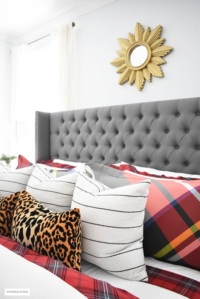 Gorgeous red and white tartan bedding from Williams-Sonoma paired with leopard and stripes is festive and cozy for the holidays and winter season.