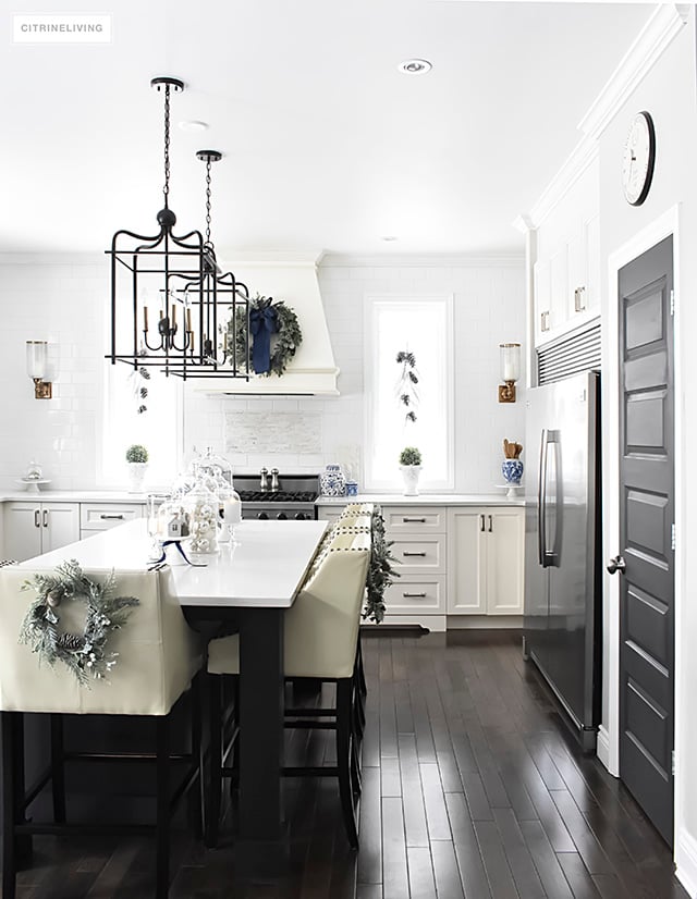 A beautiful Christmas kitchen with blue and white chinoiserie, paired with holiday greenery for a sophisticated, festive and elegant look.