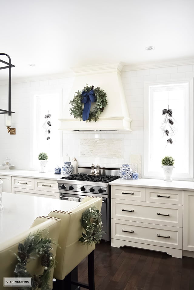 A beautiful Christmas kitchen with blue and white chinoiserie, paired with holiday greenery for a sophisticated, festive and elegant look.