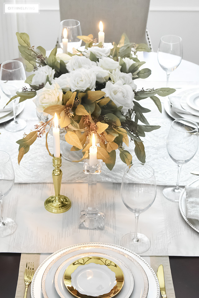 A gorgeous neutral Valentine's table with tones of white layered with metallic accents and a beautiful white rose centrepiece.