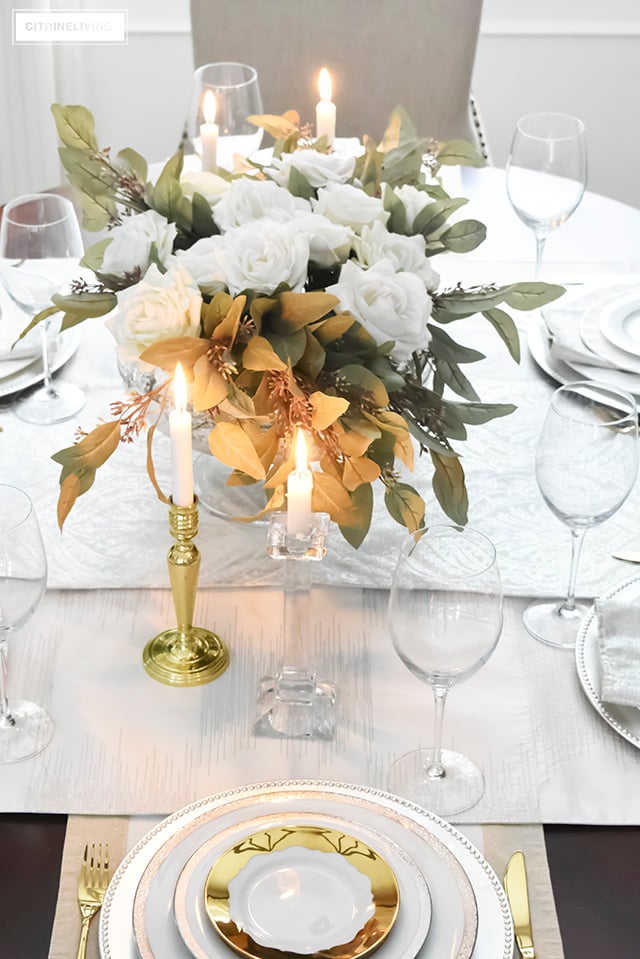 A gorgeous neutral Valentine's table with tones of white layered with metallic accents and a beautiful white rose centrepiece.